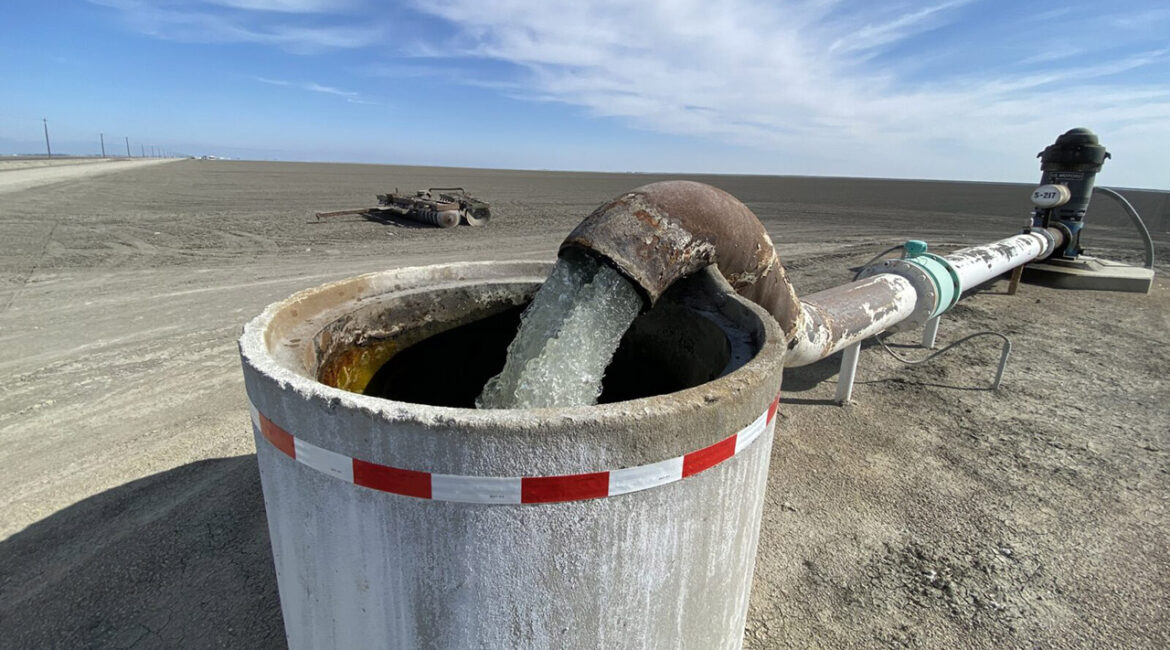 Image of a groundwater pump sending water into an irrigation holding pipe