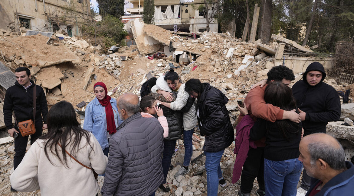 Displaced residents hug as they stand in front of the rubble of their destroyed house in Baalbek, eastern Lebanon, Thursday, Nov. 28, 2024. (AP Photo/Hassan Ammar)