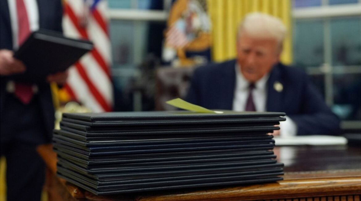 FILE - President Donald Trump signs executive orders in the Oval Office of the White House, Jan. 20, 2025, in Washington. (AP File)