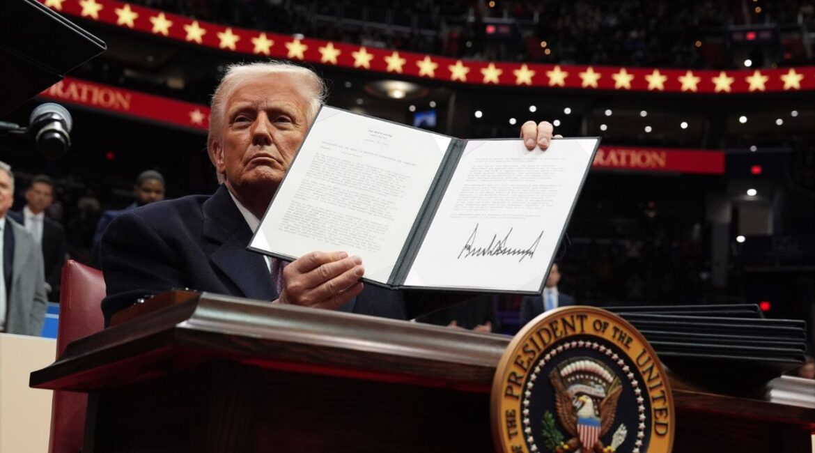 President Donald Trump signs an executive order as he attends an indoor Presidential Inauguration parade event at Capital One Arena, Monday, Jan. 20, 2025, in Washington. (AP/Evan Vucci)