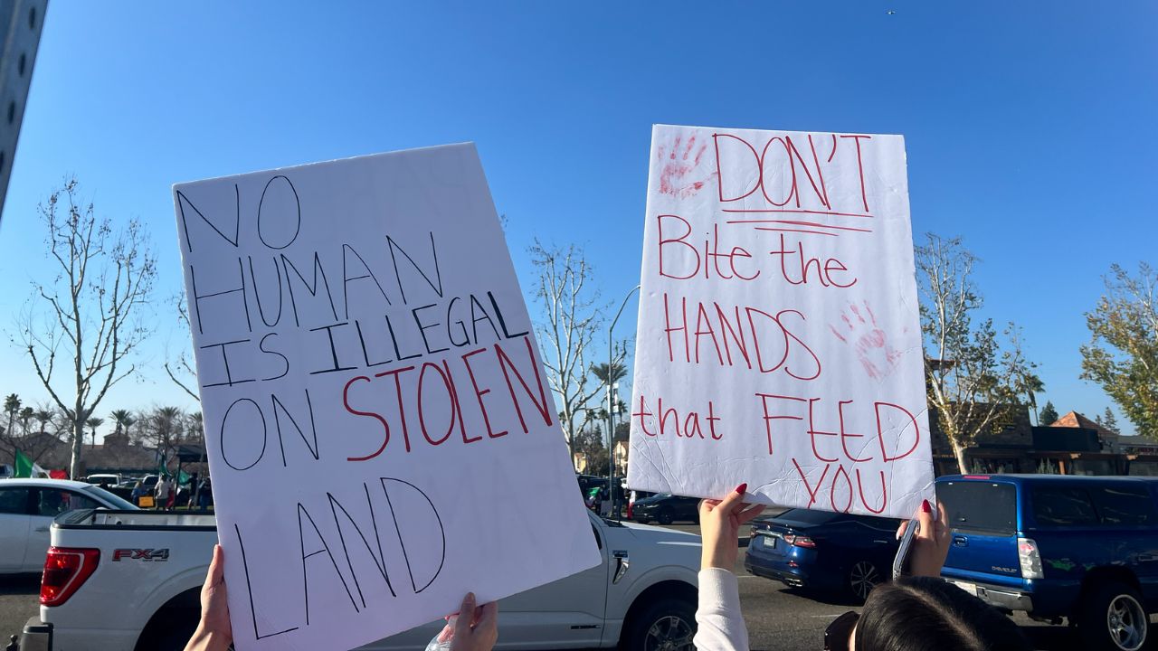 Two signs, one saying "NO HUMAN IS ILLEGAL ON STOLEN LAND" and "DON'T BITE the HANDS that FEED YOU" being held up at the anti-deportation protest on Sunday, Jan. 12, 2025. (Anthony W. Haddad)