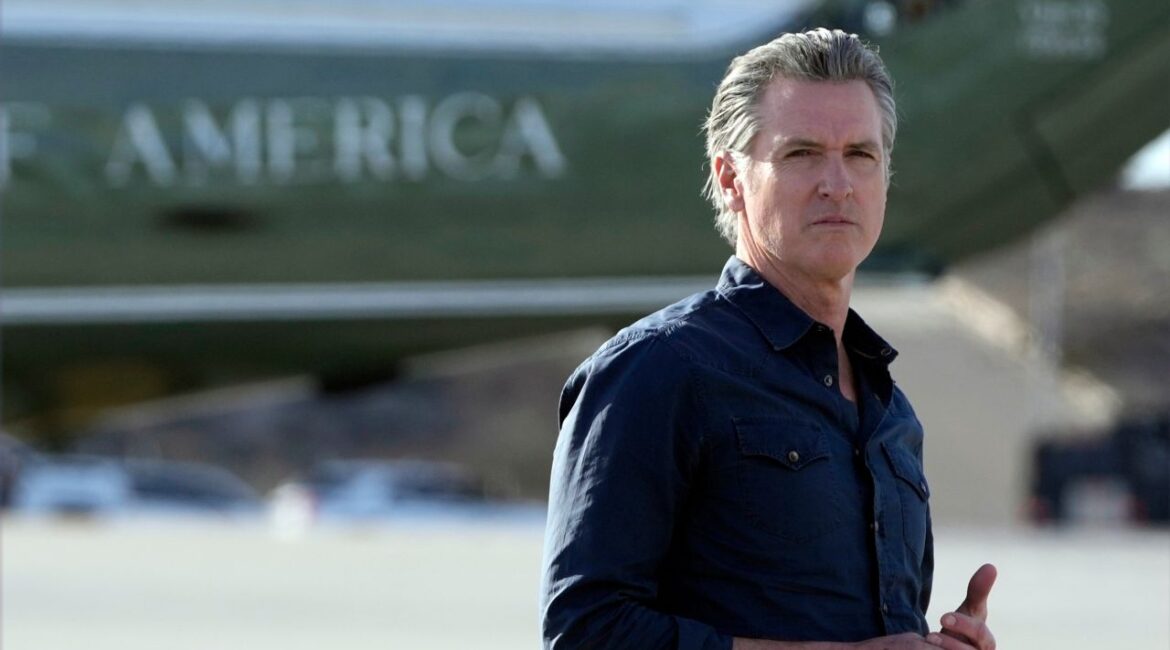 FILE - California Gov. Gavin Newsom waits for President Donald Trump and first lady Melania Trump to step off Air Force One upon their arrival at Los Angeles International Airport in Los Angeles, Jan. 24, 2025. (AP Photo/Mark Schiefelbein, File)
