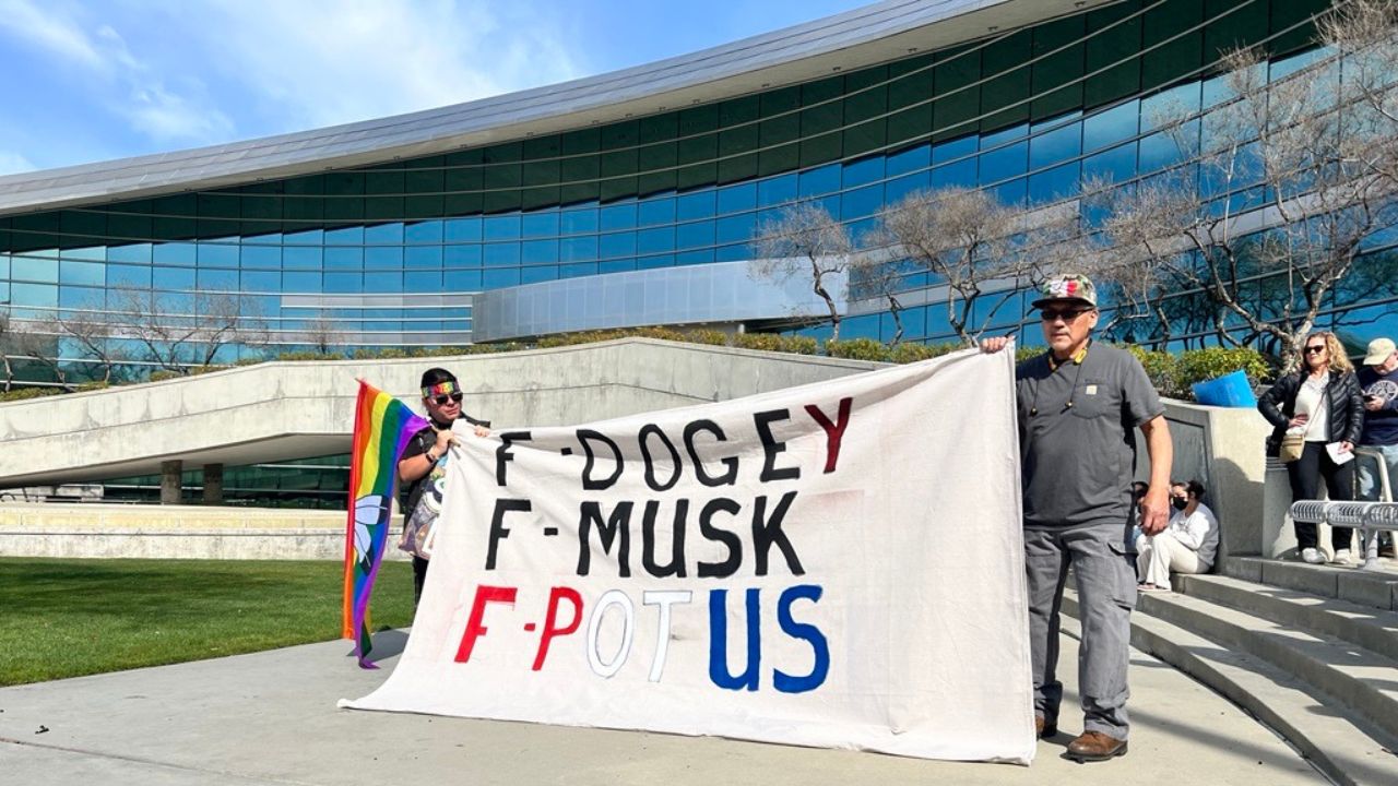 Protesters holding a sign at Fresno's protest on Monday, Feb. 17, 2025. (GV Wire/Anthony W. Haddad)