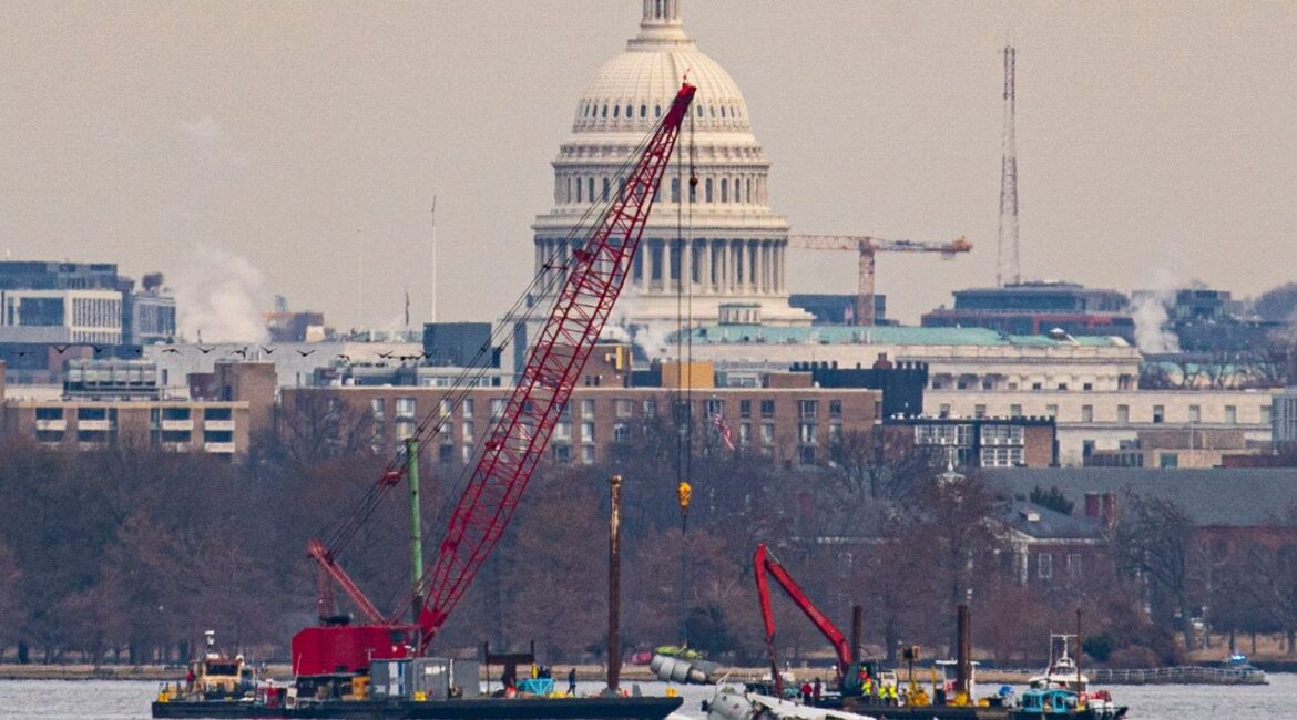 With the Capitol Building in the background, a crane lifts an engine from the wreckage of an American Airlines plane that crashed last week after a collision with a Black Hawk helicopter on the Potomac River in Arlington, Va., Feb. 3, 2025. The authorities have drawn closer to finding and identifying all victims of the midair collision last week between a commercial jet and an Army helicopter just outside Washington, officials said at a news briefing on Sunday. (Al Drago/The New York Times)
