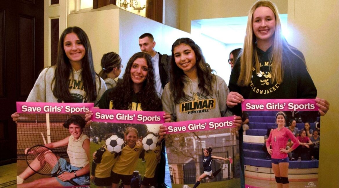 Student athletes hold signs during a hearing to consider bills to pass rules banning transgender student-athletes Tuesday, April 1, 2025, in Sacramento, Calif. (AP/Yuri Avila)