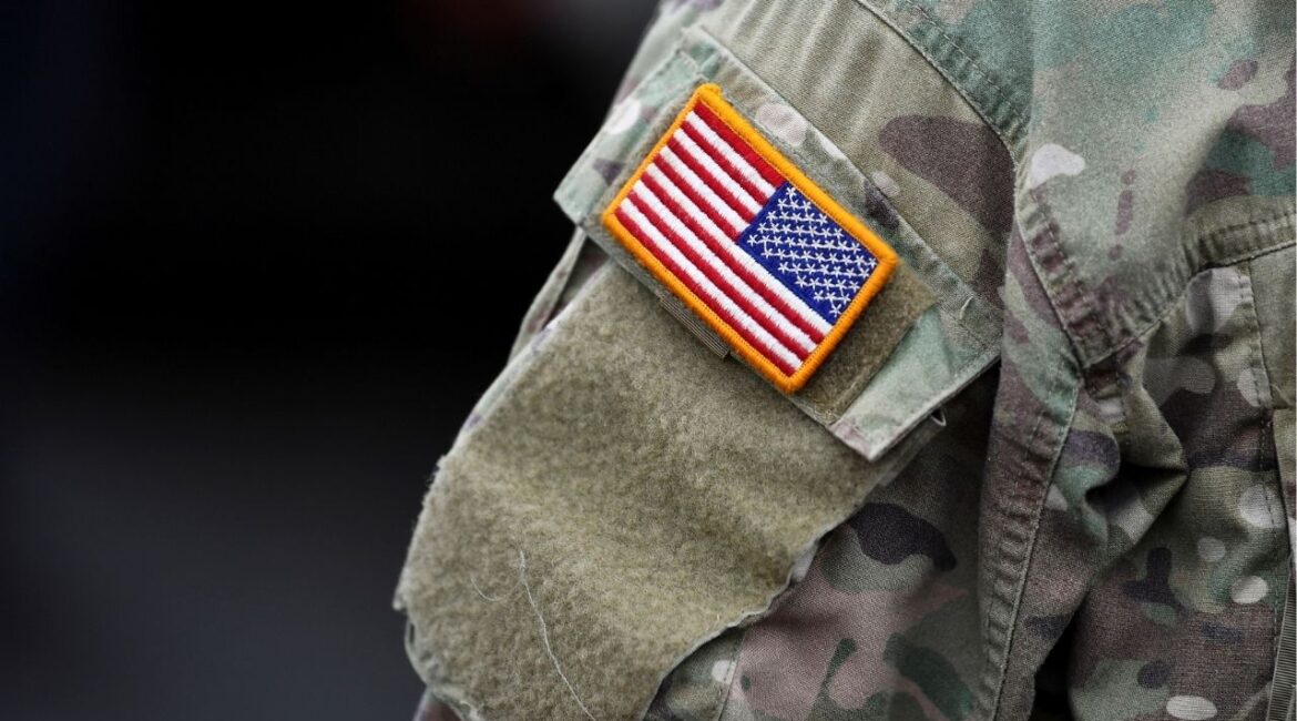 An U.S. flag is pictured on the arm of a soldier of the U.S. 2nd Cavalry Regiment as gear is prepared for deployment to Romania at Rose Barracks in Vilseck, Germany, February 9, 2022. REUTERS/Lukas Barth/File Photo