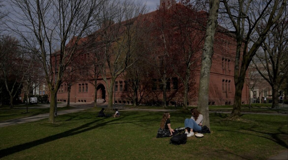 People sit on the grass at the campus of Harvard University in Cambridge, Massachusetts, U.S., April 15, 2025. REUTERS/Faith Ninivaggi/File Photo