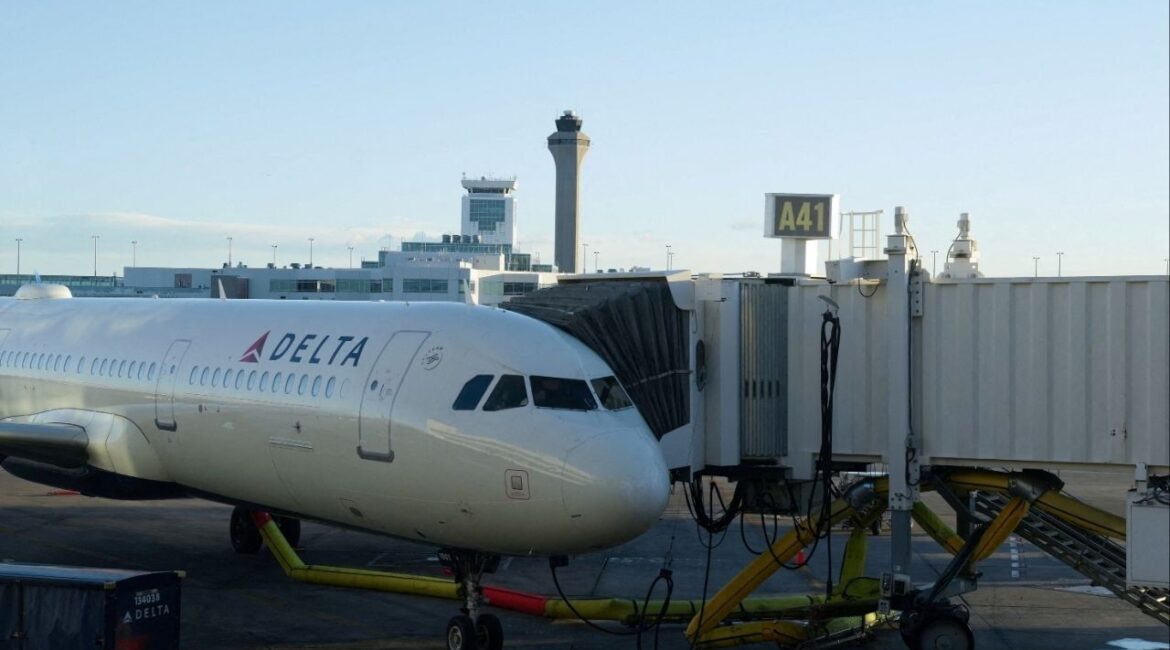 The air traffic control tower is seen from the Denver International Airport terminal, as a Delta flight sits at the gate, in Denver, Colorado, U.S., May 15, 2025. REUTERS/Megan Varner