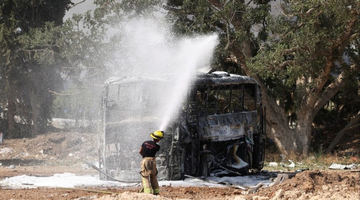 A firefighter works to extinguish a fire on a bus following a missile attack from Iran, in Herzliya, Israel, June 17, 2025. (Reuters/Ronen Zvulun)