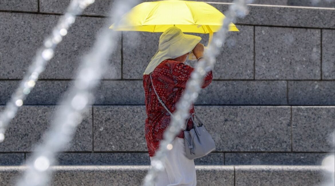 A woman shades her self with an umbrella at the World War II Memorial, amid a dangerous heat wave afflicting the eastern half of the United States, in Washington, U.S., June 24, 2025. (Reuters/Evelyn Hockstein)