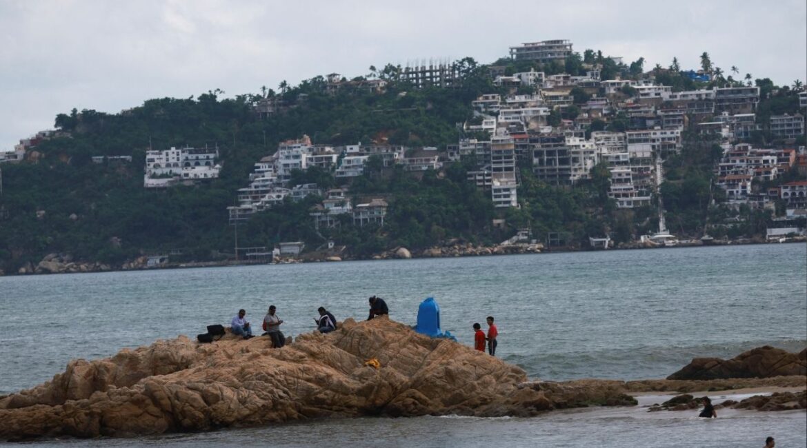 People are seen at a beach, as hurricane Erick strengthens off Mexico's Pacific Coast, in Acapulco, Guerrero state, Mexico, June 18, 2025. (Reuters/Henry Romero)