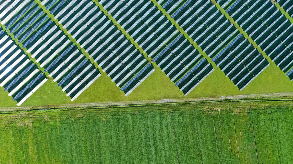 Overhead image of solar panels adjacent to fields of grass