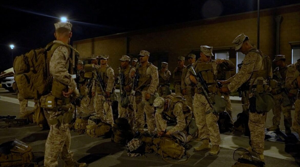 U.S. Marines stand with their packs and weapons, as protests against federal immigration sweeps continue, in greater Los Angeles, California, U.S., June 9, 2025, in this screen grab taken from a handout video. (DVIDS/Handout via REUTERS/File Photo)