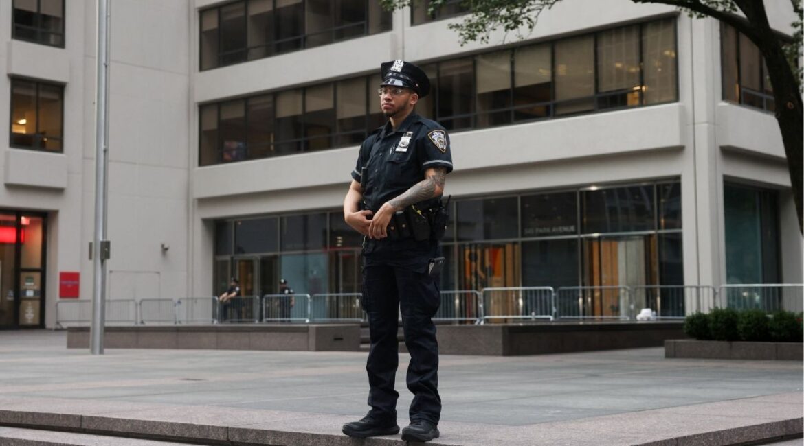 A NYPD officer stands in front of the building where a shooting had taken place the day before in the Manhattan borough of New York City, U.S., July 29, 2025. (Reuters/Kylie Cooper)