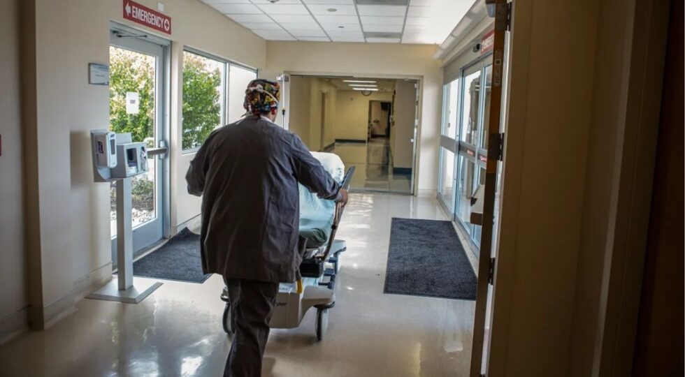 A medical worker pushing a bed through the corridors of Hazel Hawkins Memorial Hospital in Hollister on March 30, 2023. Photo by Larry Valenzuela, CalMattersCatchLight Local