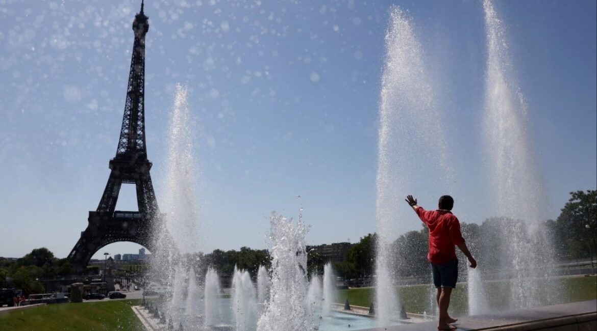 A tourist cools off in the Trocadero Fountain next to the Eiffel Tower as an early summer heatwave hits Paris, France, July 1, 2025. (Reuters/Tom Nicholson)