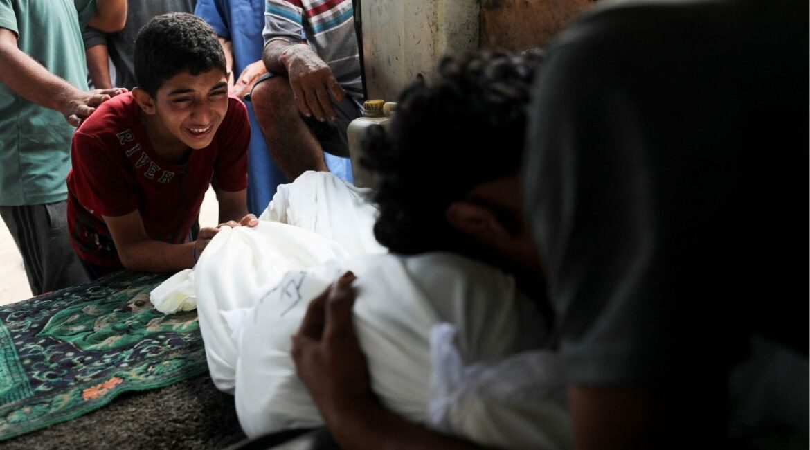 Mourners react next to a body during the funeral of Palestinians killed in an early morning Israeli strike, according to medics, at Al-Shifa Hospital in Gaza City, July 19, 2025. (Reuters/Mahmoud Issa)