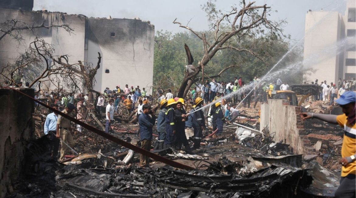 People gather near a damaged building and trees as firefighters work at the site where an Air India plane crashed in Ahmedabad, India, June 12, 2025. (Reuters File)