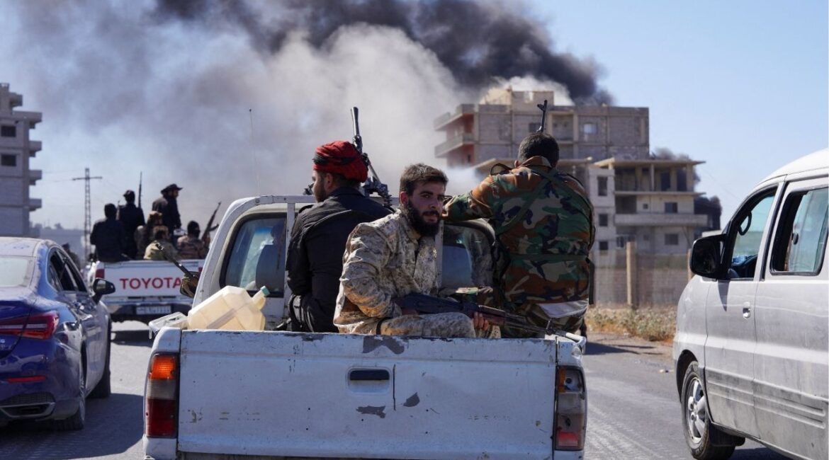 Smoke rises while Syrian security forces sit in the back of a truck as Syrian troops entered the predominantly Druze city of Sweida on Tuesday following two days of clashes, in Sweida, Syria July 15, 2025. (Reuters/Karam al-Masri)