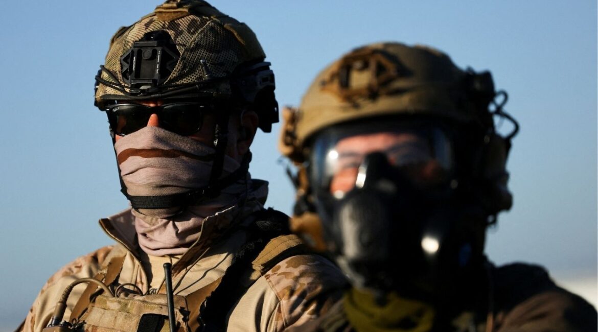 U.S. federal agents look on as they stand guard while blocking a road leading to an agricultural facility where U.S. federal agents and immigration officers carried out an operation, in Camarillo, California, July 10. (Reuters/Daniel Cole)