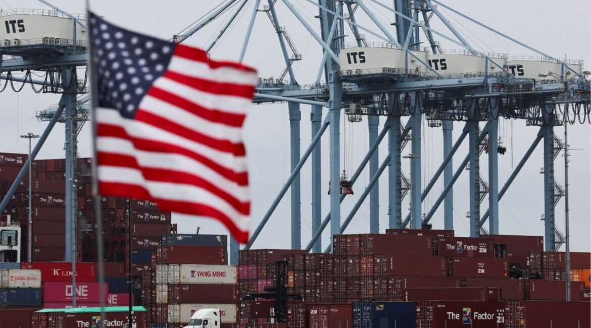 U.S. flag flutters in front of shipping containers at the Port of Long Beach in Long Beach, California, U.S., July 11, 2025. (Reuters/Daniel Cole)