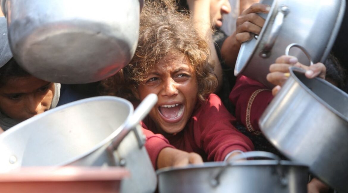 A child reacts surrounded by pots as Palestinians wait to receive food from a charity kitchen in Khan Younis, southern Gaza Strip, August 21, 2025. (Reuters/Hatem Khaled)