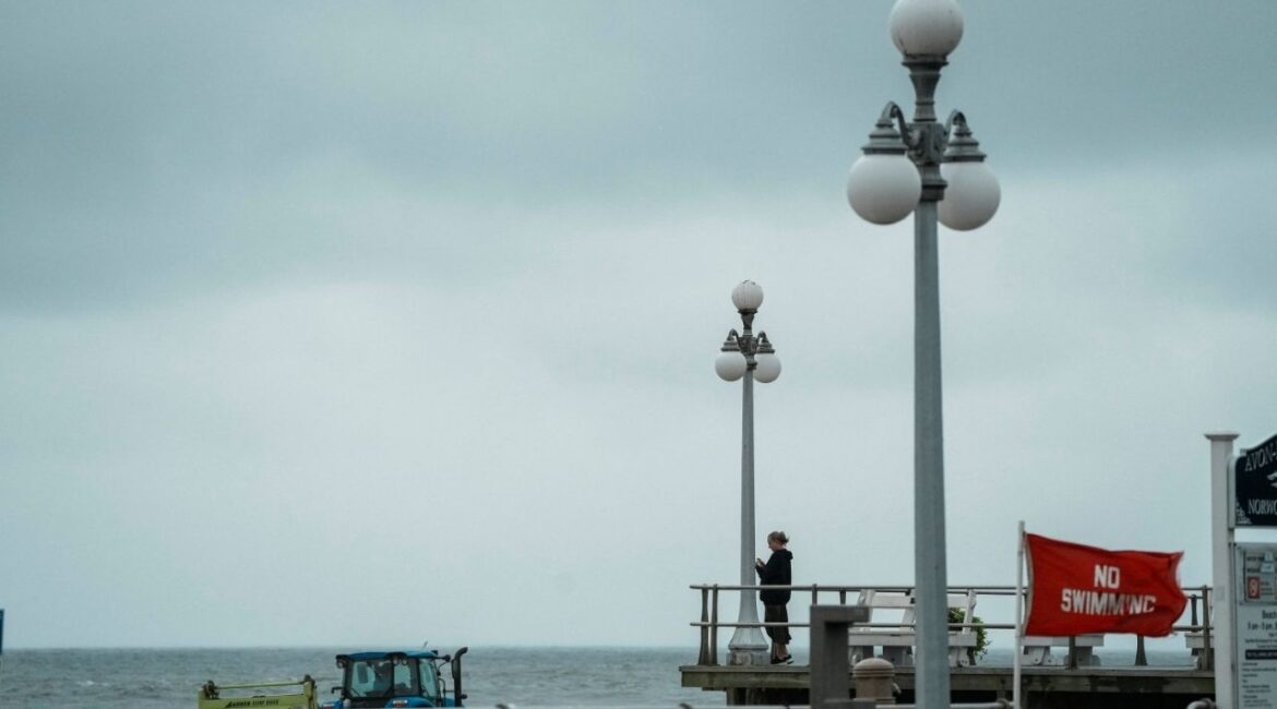 A person stands by the beach during Hurricane Erin, the first hurricane of the 2025 Atlantic season, in Avon-by-the-Sea, New Jersey, U.S., August 20, 2025. (Reuters/Eduardo Munoz)