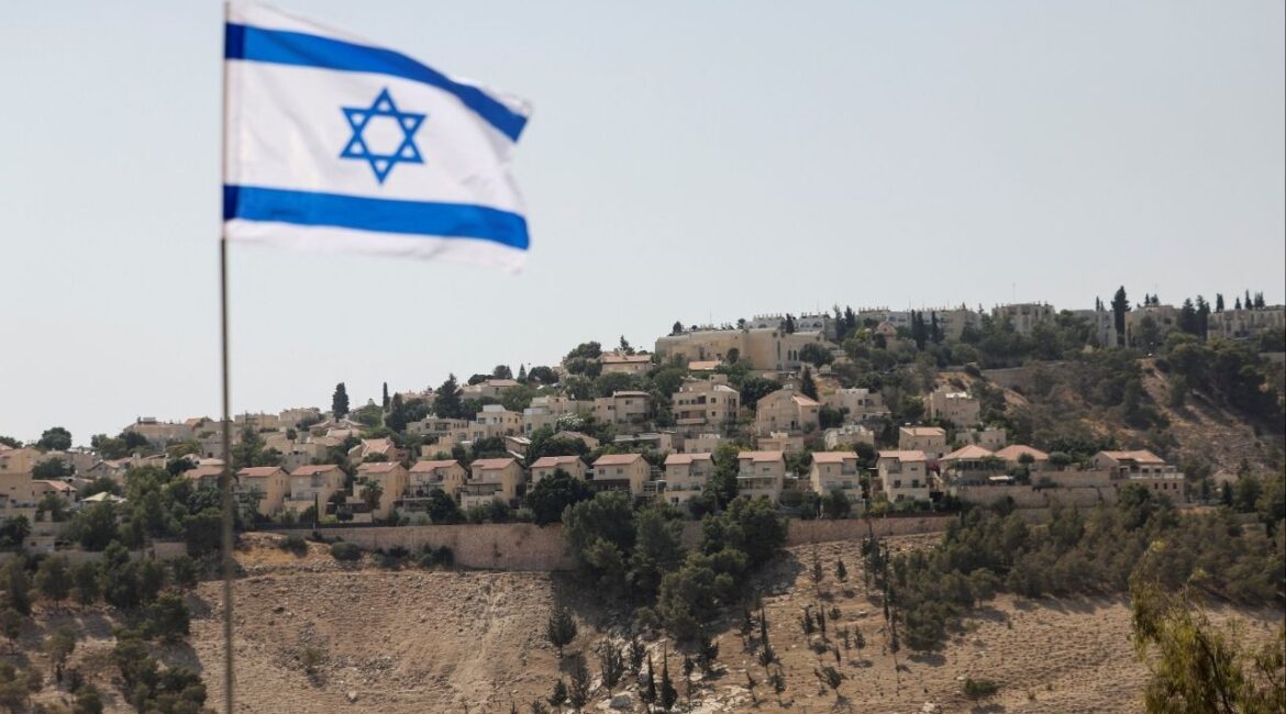 An Israeli flag flutters, as part of the Israeli settlement of Maale Adumim is visible in the background, in the Israeli-occupied West Bank, August 14, 2025. (Reuters/Ronen Zvulun)
