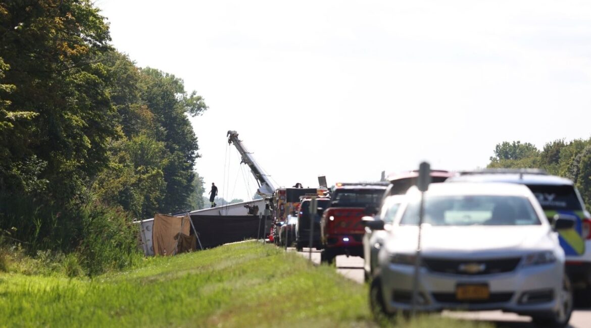 First responders work at the scene of a bus crash on the New York State Thruway about 30 miles east of Buffalo, N.Y., on Friday afternoon, Aug. 22, 2025. The tour bus traveling from Niagara Falls to New York City crashed on a highway outside Buffalo on Friday, killing multiple passengers, including at least one child, and leaving some people trapped beneath the vehicle, officials said. (Lauren Petracca/The New York Times)