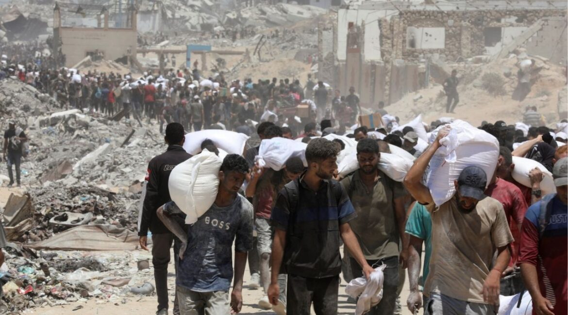 Palestinians carry aid supplies that entered Gaza through Israel, in Beit Lahia in the northern Gaza Strip, August 1, 2025. (Reuters/Dawoud Abu Alkas)
