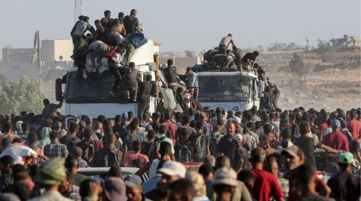 Palestinians climb onto trucks as they seek aid supplies in Khan Younis, southern Gaza Strip, August 4, 2025. REUTERS/Hatem Khaled