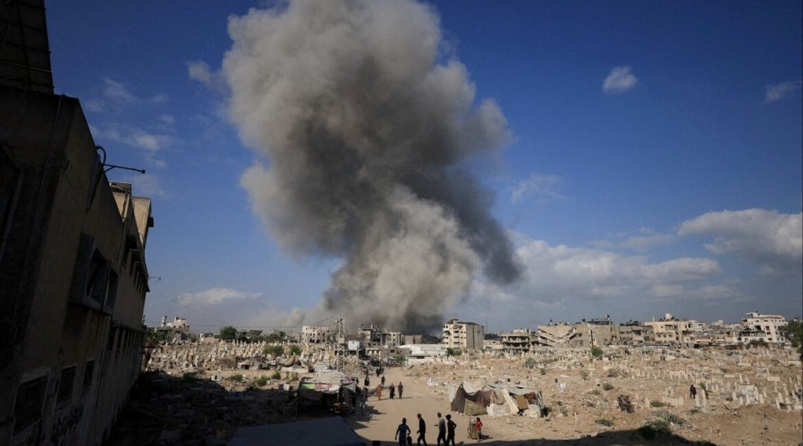 Palestinians gather near a cemetery as smoke rises following an explosion during an Israeli operation in Gaza City, August 28, 2025. (Reuters File)