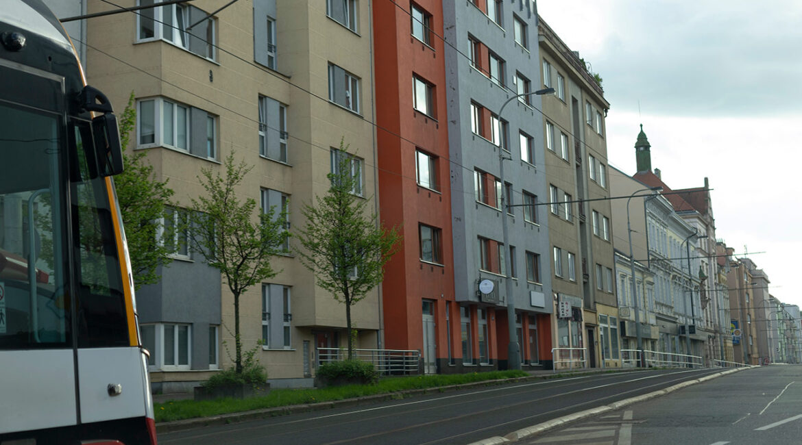 This is a city street that showcases modern residential buildings, as well as a public bus for community transit and transport