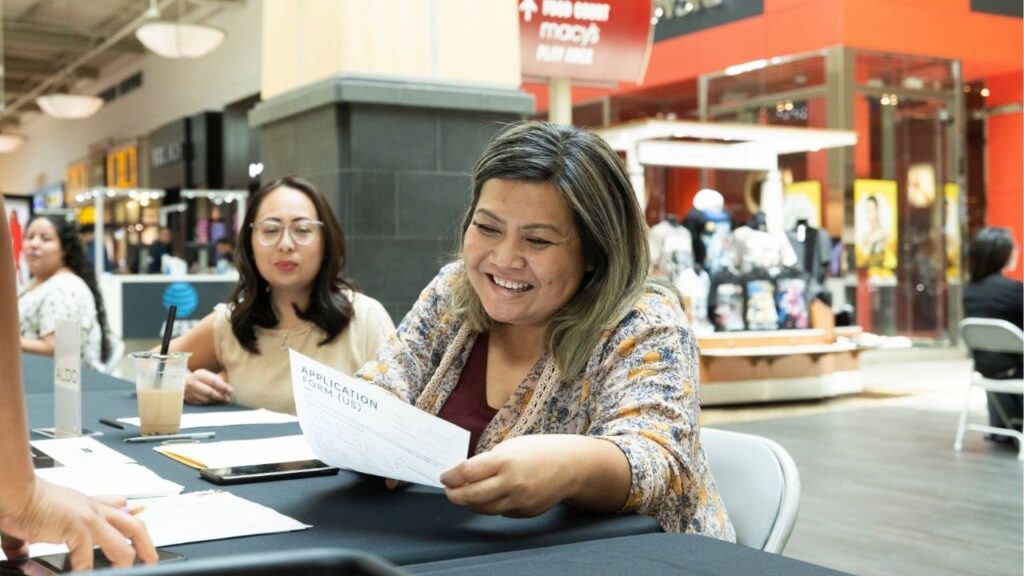 A business representative reviews a resume at the 2022 Fashion Fair Mall job fair. (Courtesy of Fashion Fair Mall)