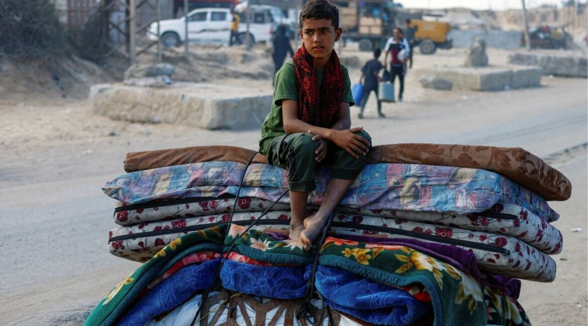 A displaced Palestinian boy, fleeing northern Gaza due to an Israeli military operation, sits atop belongings as he moves southward after Israeli forces ordered residents of Gaza City to evacuate to the south, in the central Gaza Strip September 17, 2025. (Reuters/Mahmoud Issa)