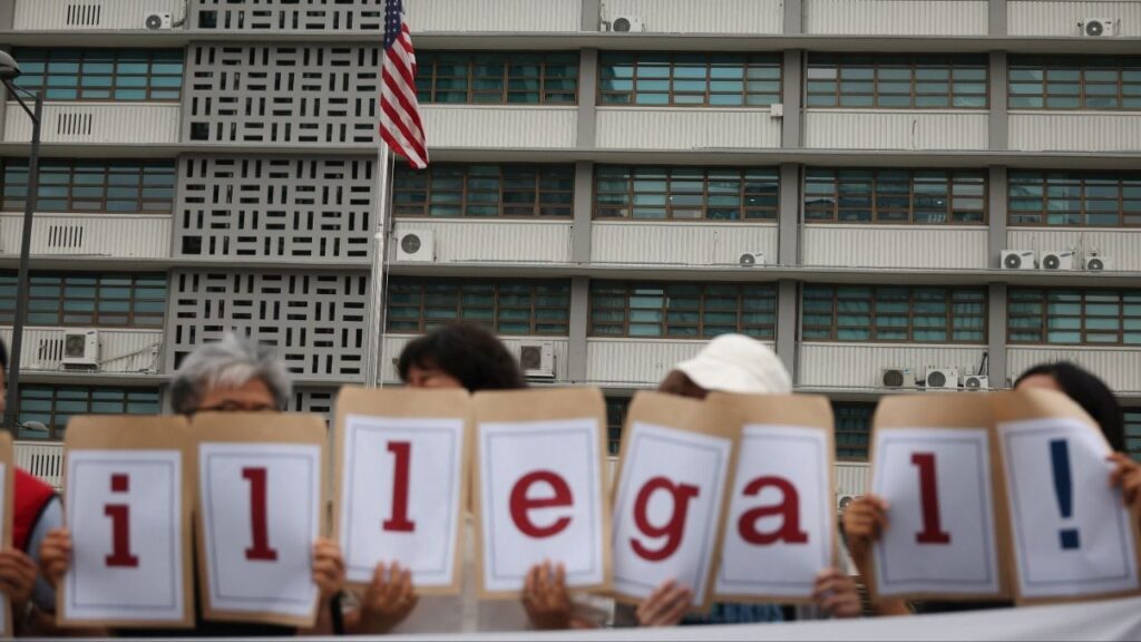 Activists hold signs that reads “illegal!” during a press conference to protest against huge immigration raid last week at the site of a U.S. car battery project involving Hyundai Motor and LG Energy Solution in the U.S. state of Georgia, in front of the U.S. embassy in Seoul, South Korea, September 9, 2025. (Reuters/Kim Hong-Ji)