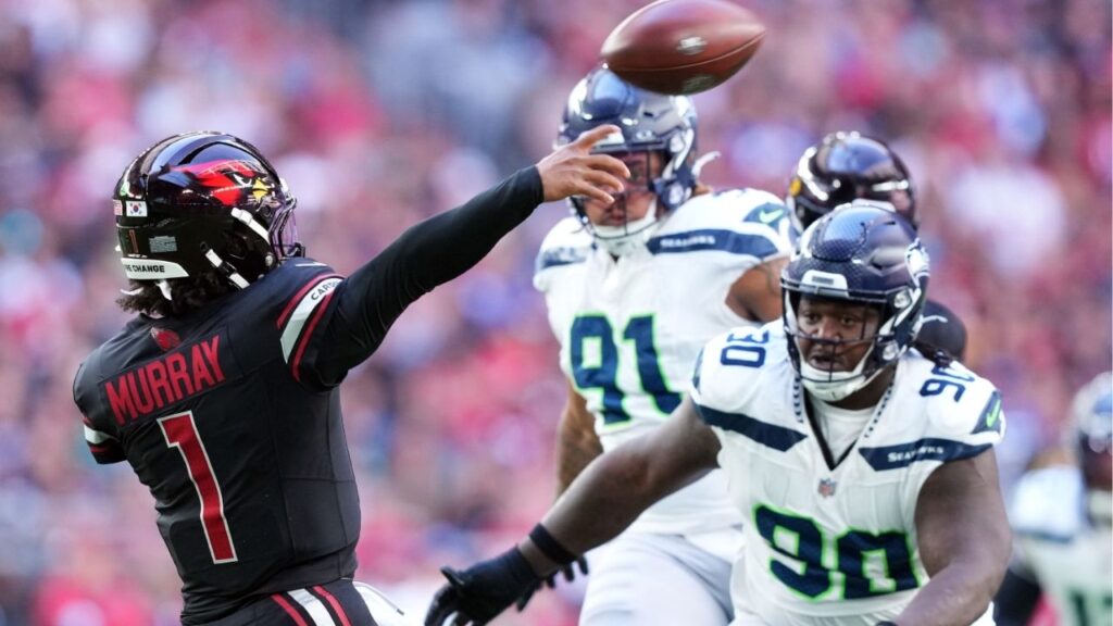 Dec 8, 2024; Glendale, Arizona, USA; Arizona Cardinals quarterback Kyler Murray (1) throws while being pressured by Seattle Seahawks defensive tackle Jarran Reed (90) during the first half at State Farm Stadium. (Joe Camporeale-Imagn Images)