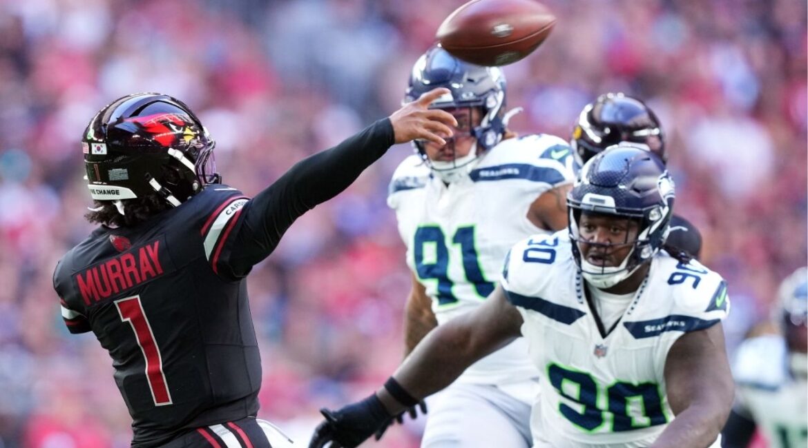 Dec 8, 2024; Glendale, Arizona, USA; Arizona Cardinals quarterback Kyler Murray (1) throws while being pressured by Seattle Seahawks defensive tackle Jarran Reed (90) during the first half at State Farm Stadium. (Joe Camporeale-Imagn Images)