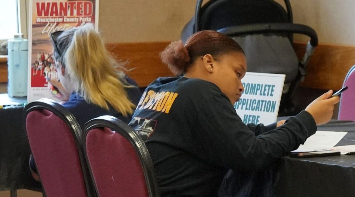 Job seekers fill out applications during a job fair. (USA Today Network Via Reuters)