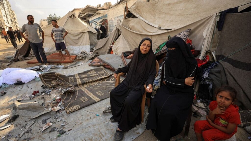 Palestinians women and a girl sit while others inspect the site of an overnight Israeli strike on a tent, in Gaza City, September 7, 2025. (Reuters File)
