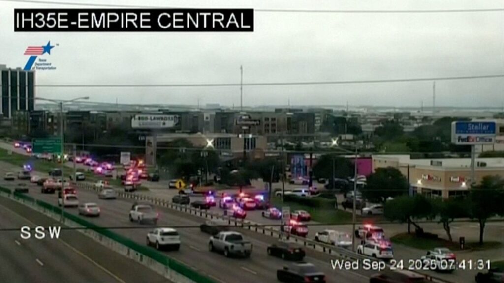 Police cars and ambulances stand outside a ICE facility where a shooting took place in Dallas, Texas, U.S. September 24, 2025 in this screengrab taken from a handout traffic camera video. Texas Department Of Transportation /via Reuters TV/Handout via REUTERS