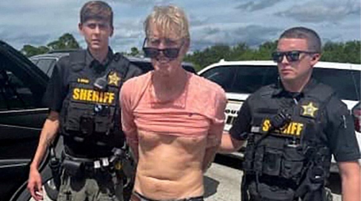Ryan W. Routh, suspected of attempting to assassinate Republican presidential nominee and former U.S. President Donald Trump at his West Palm Beach golf course, stands handcuffed between two Martin County Sheriff's office deputies after his arrest during a traffic stop near Palm City, Florida, U.S., September 15, 2024. (Reuters File)