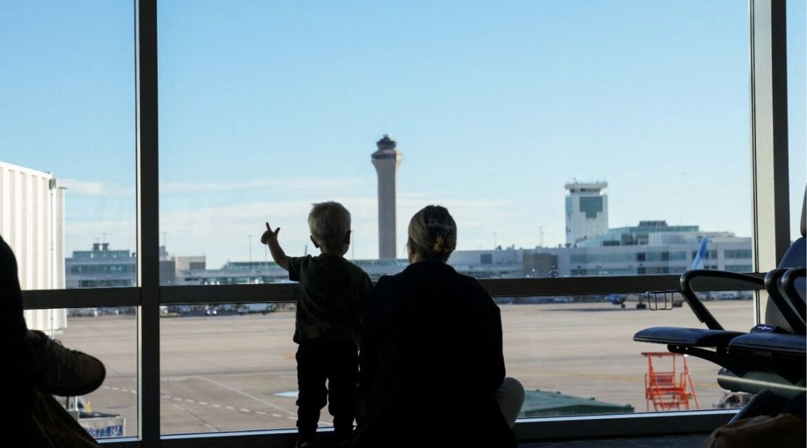 The air traffic control tower is seen from the gate as a woman and a child look out at the Denver International Airport terminal, in Denver, Colorado, U.S., May 15, 2025. (Reuters/Megan Varner)