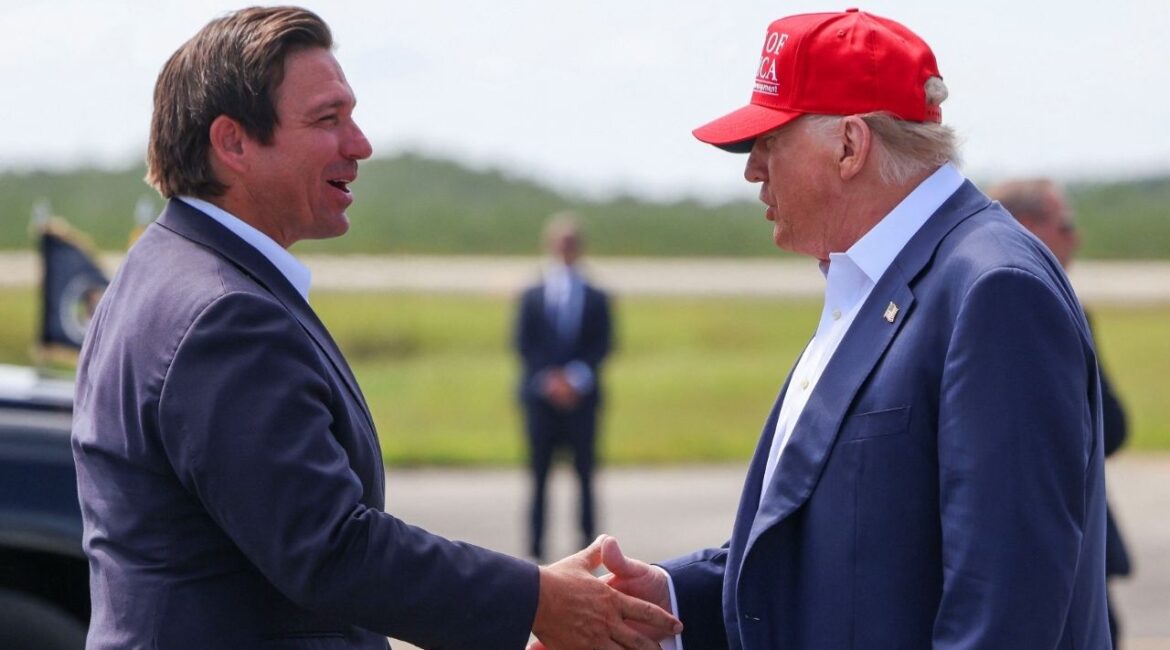 U.S. President Donald Trump shakes hands with Florida Governor Ron DeSantis at the Dade-Collier Training and Transition Airport on the day of the opening of a temporary migrant detention center informally known as "Alligator Alcatraz" in Ochopee, Florida, U.S., July 1, 2025. (Reuters/Evelyn Hockstein)