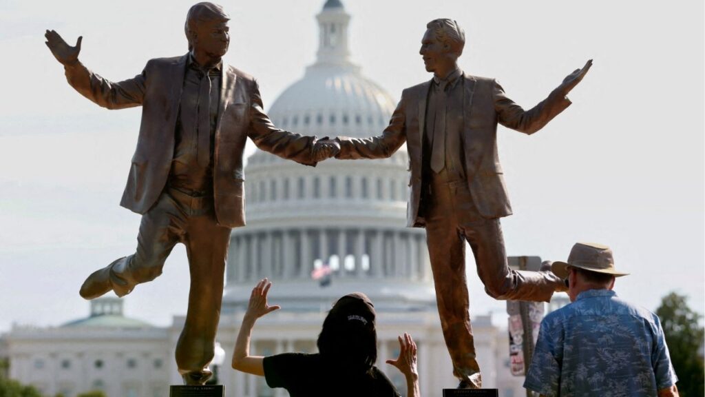 Visitors look up at a pop-up statue depicting U.S. President Donald Trump and disgraced financier and sex offender Jeffrey Epstein dancing together near the U.S. Capitol in Washington, D.C., U.S., September 23, 2025. (Reuters/Kevin Lamarque)