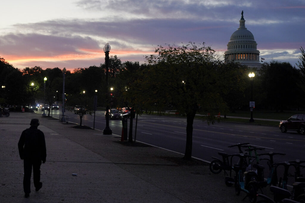 A person walks, with the U.S. Capitol dome in the background, during the first day of a partial government shutdown in Washington, D.C., U.S., October 1, 2025. (Reuters/Nathan Howard)