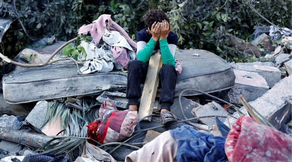A Palestinian boy reacts as he sits at the site of an overnight Israeli strike on a house, in Nuseirat, central Gaza Strip, October 29, 2025. (Reuters/Mahmoud Issa)