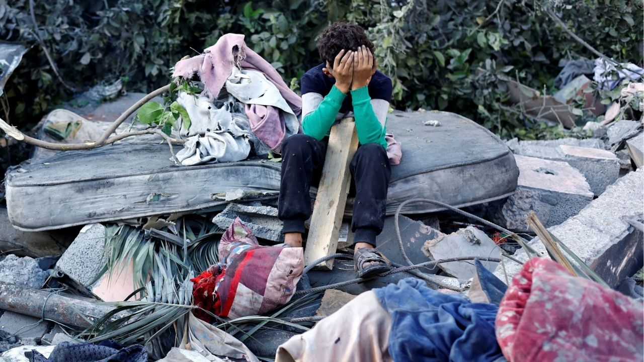 A Palestinian boy reacts as he sits at the site of an overnight Israeli strike on a house, in Nuseirat, central Gaza Strip, October 29, 2025. (Reuters/Mahmoud Issa)