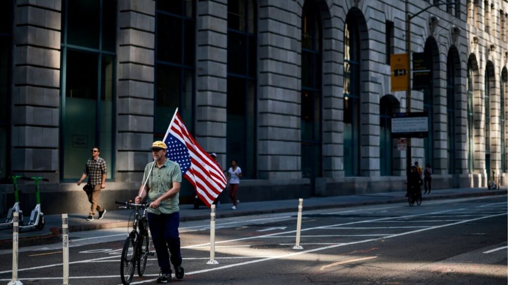 A man carrying a U.S. flag pushes a bike, on the day of a "No Kings" protest against U.S. President Donald Trump's policies, in San Francisco, California, U.S., October 18, 2025. (Reuters/Carlos Barria)