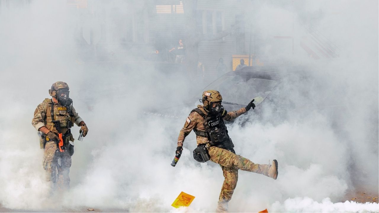 A member of the Border Patrol Tactical Unit, BORTAC, kicks a tear gas canister toward a crowd of people during clashes with community members amid immigration raids in the East Side neighborhood of Chicago, Oct. 14, 2025. A federal judge in Chicago said on Thursday that she was “profoundly concerned” that federal agents might have violated a court order that she had issued setting strict limits on their use of tear gas and requiring them to give protesters warnings to disperse, and also said she would order federal agents to wear body cameras. (Jamie Kelter Davis/The New York Times)